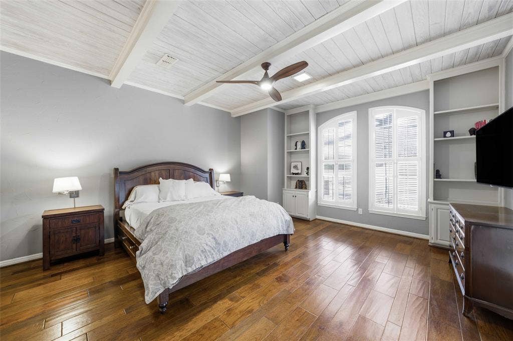 Bedroom with dark wood finished floors, ceiling fan, and a wood ceiling with exposed beams