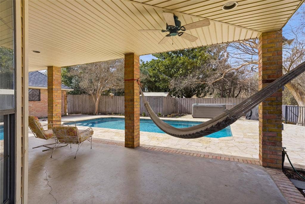 View of swimming pool with patio surround, a fenced backyard, and a water slide