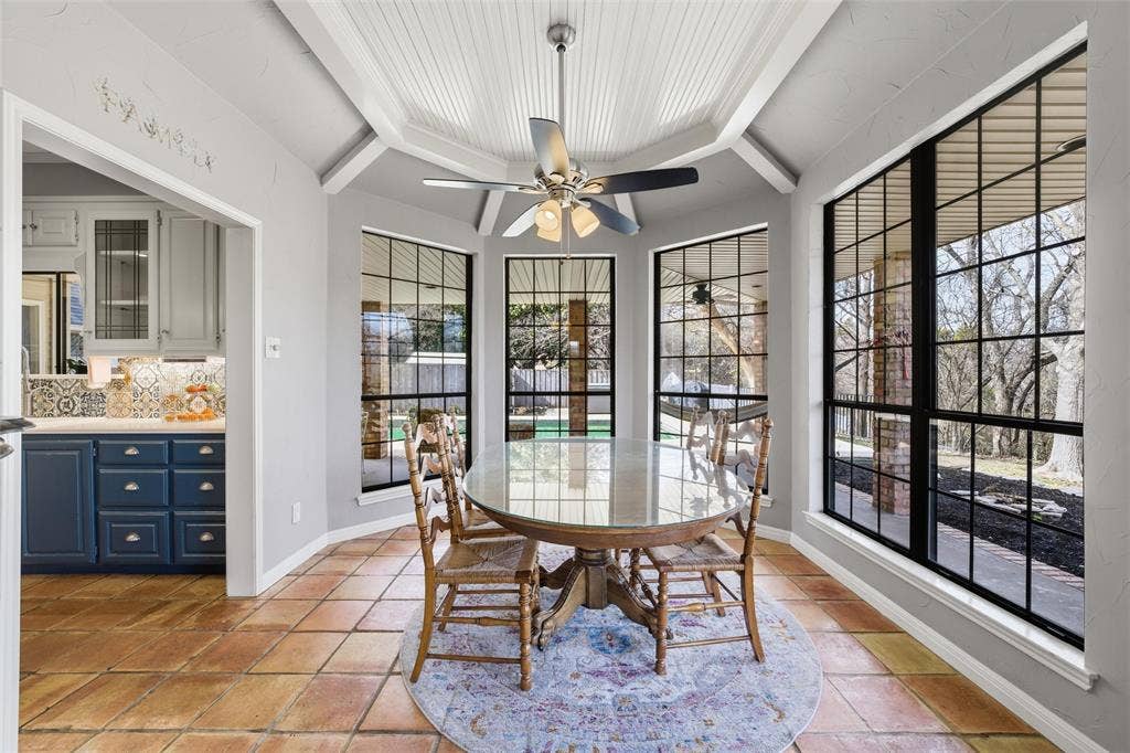 Dining space featuring a ceiling fan and baseboards