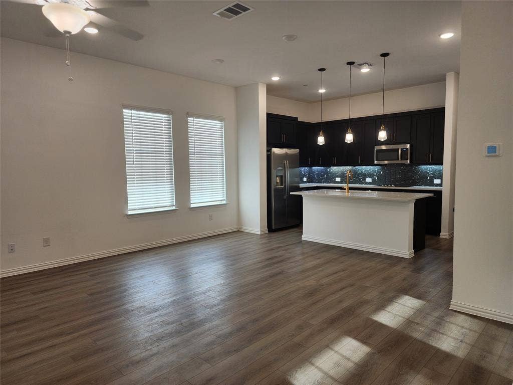 627 Redwood Way, Mansfield, TX 76063 Kitchen featuring dark cabinetry, pendant lighting, stainless steel appliances, and open floor plan