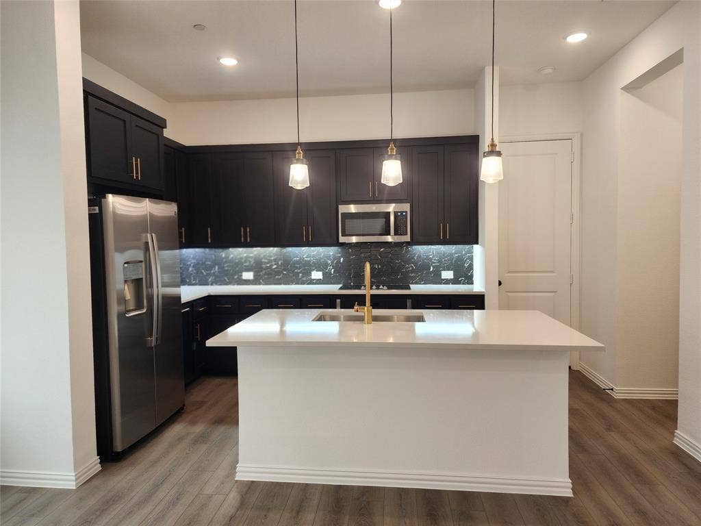 627 Redwood Way, Mansfield, TX 76063 Kitchen with stainless steel appliances, hanging light fixtures, a center island with sink, and dark wood-style flooring