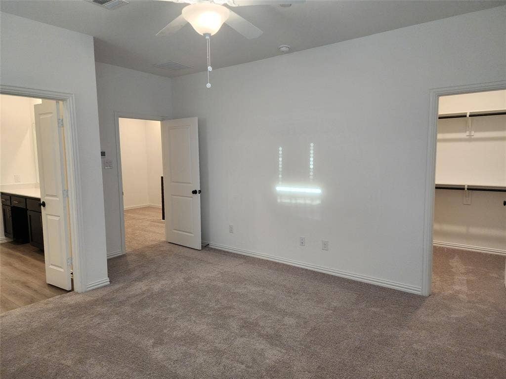 627 Redwood Way, Mansfield, TX 76063 Unfurnished bedroom with light colored carpet, a walk in closet, ceiling fan, and ensuite bathroom