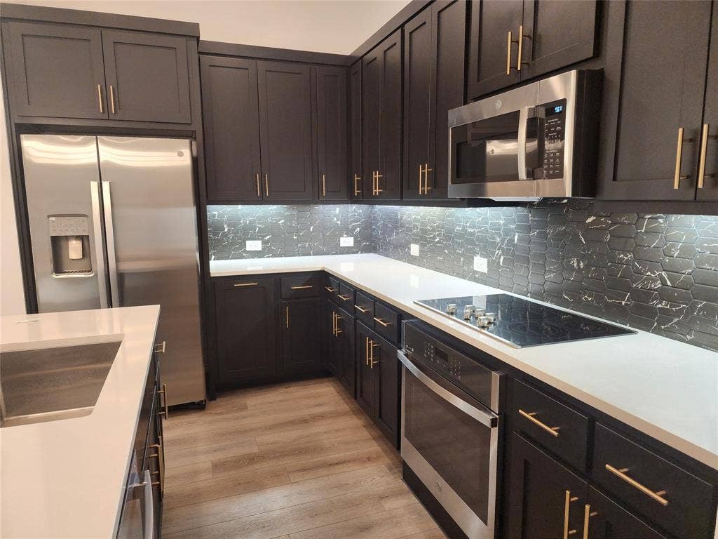627 Redwood Way, Mansfield, TX 76063 Kitchen with stainless steel appliances, light wood finished floors, tasteful backsplash, and light stone countertops