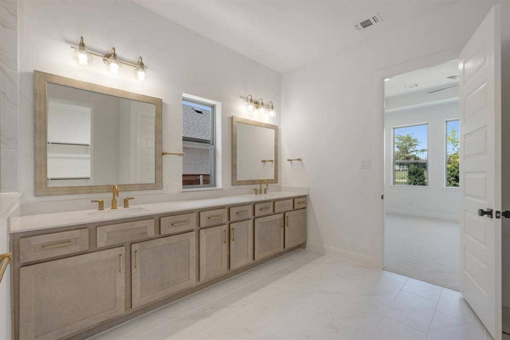 3283 Jersey Drive, Midlothian, TX 76065 Double vanity with light wood-finish cabinetry and gold-tone hardware