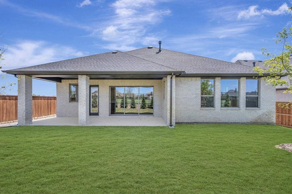 3283 Jersey Drive, Midlothian, TX 76065 Expansive backyard featuring a manicured lawn, a covered patio with block columns, and a full-light rear entry door