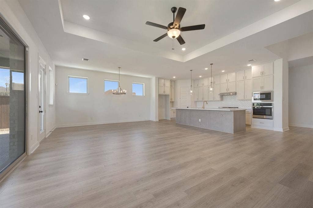 3283 Jersey Drive, Midlothian, TX 76065 Open-concept living space featuring wood-finish flooring, recessed lighting, and a tray ceiling
