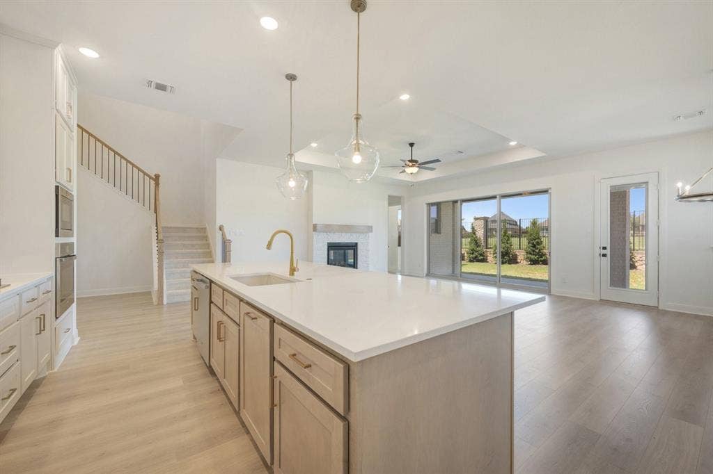 3283 Jersey Drive, Midlothian, TX 76065 Expansive kitchen island with a light-toned countertop, brass-finish faucet, and pendant lighting