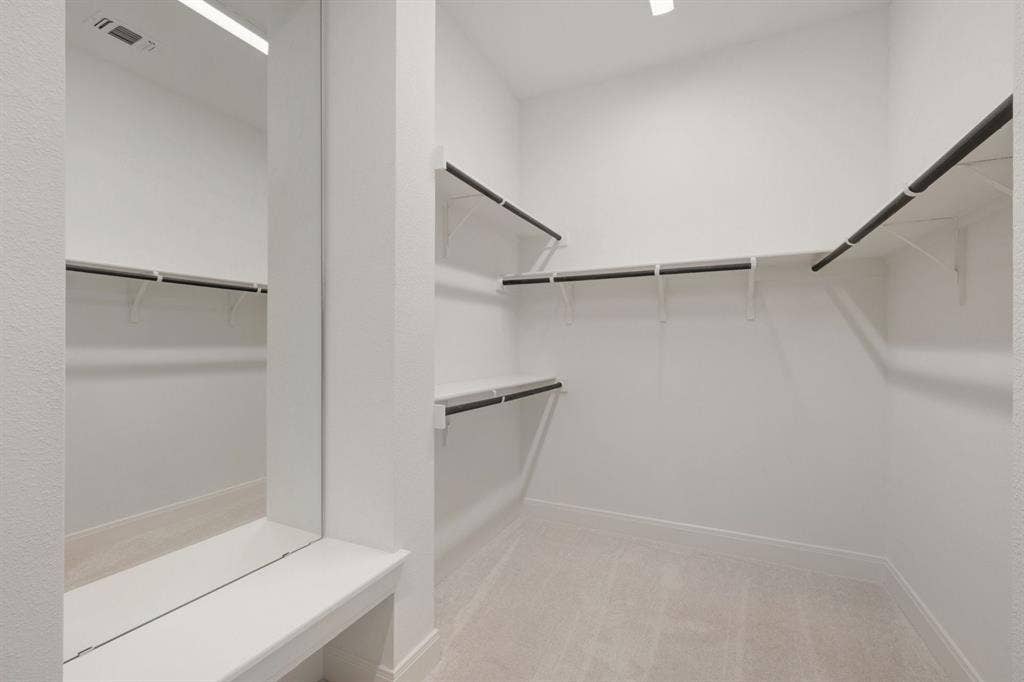 3283 Jersey Drive, Midlothian, TX 76065 Walk-in closet featuring light-toned carpeting, white walls, multiple shelving units, and hanging rods