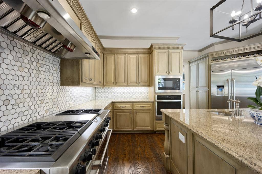 6615 Meadow Road, Dallas, TX 75230 A 6 burner range with griddle and double ovens, microwave and large island are ready for the family chef.