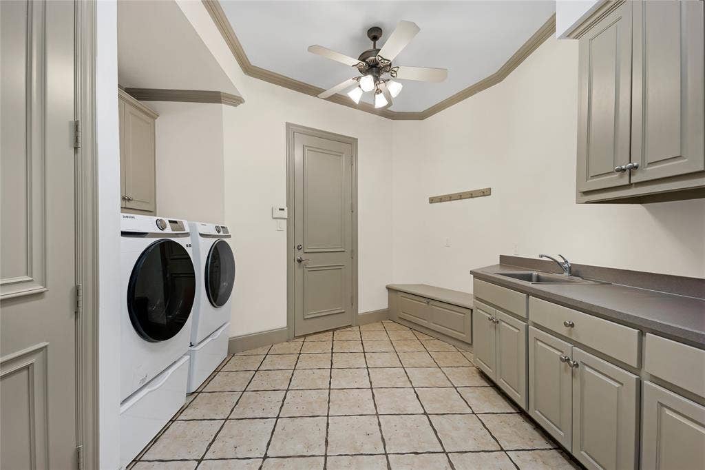 6615 Meadow Road, Dallas, TX 75230 Large laundry room with hidden laundry chute next to the sink. A closet utilizes ample storage under the back stairs, sports shoes and equipment can be put away in the storage bench and coat rack above for backpacks.