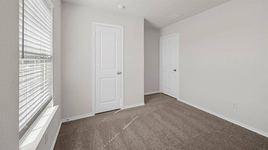 Unfurnished bedroom featuring carpet flooring and baseboards