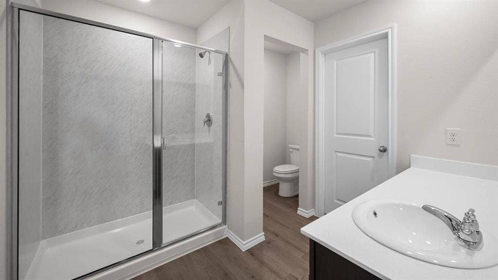 Full bathroom with vanity, a stall shower, and dark wood-style floors