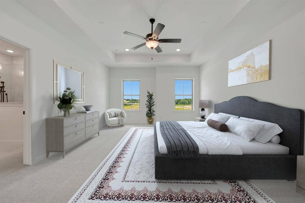 2852 Yampa Drive, McKinney, TX 75071 Bedroom featuring light-toned carpeting and a tray ceiling with a ceiling fan