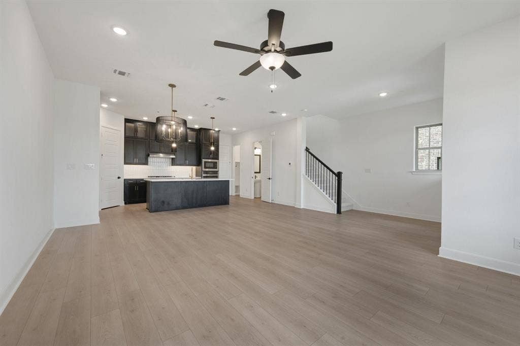 2852 Yampa Drive, McKinney, TX 75071 Open-concept living space featuring wood-finish flooring, recessed lighting, and a modern ceiling fan