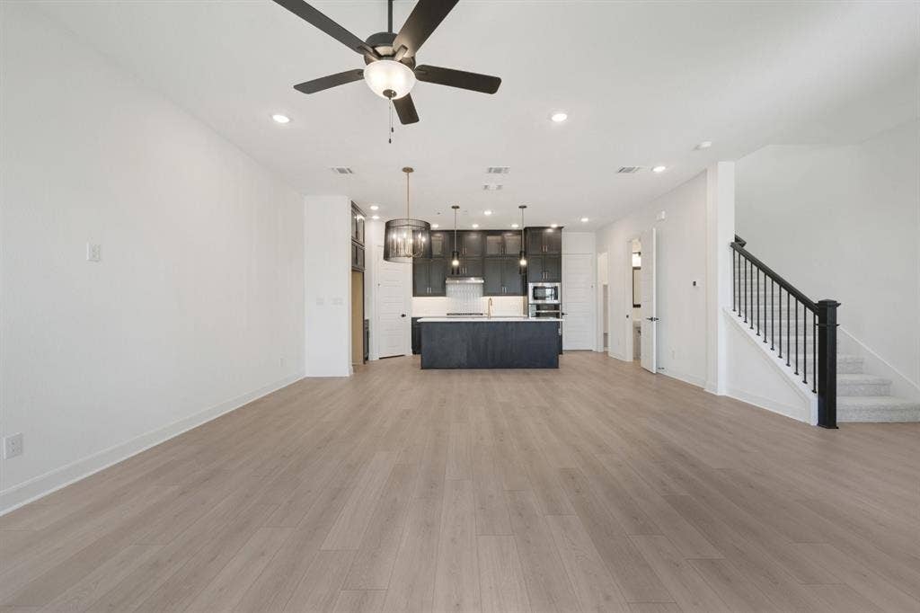 2852 Yampa Drive, McKinney, TX 75071 Open-concept living space featuring wood-finish flooring, recessed lighting, and a contemporary ceiling fan