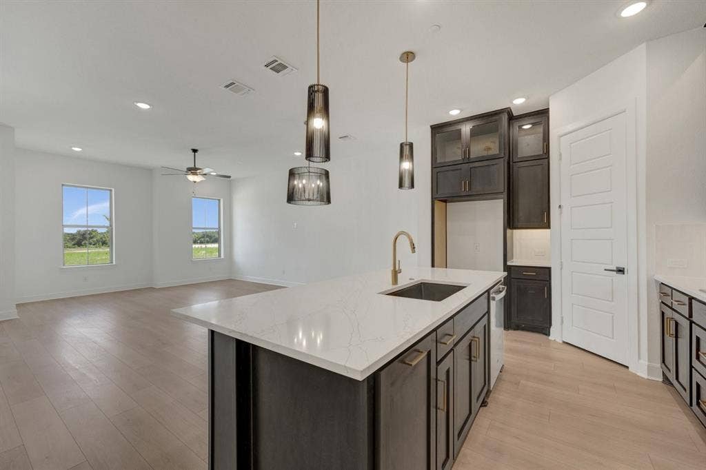 2852 Yampa Drive, McKinney, TX 75071 Open-concept kitchen and living area featuring light wood-finish flooring