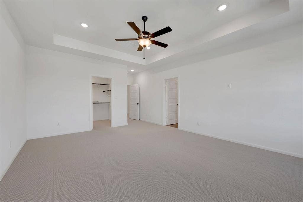 2860 Yampa Drive, McKinney, TX 75071 Spacious interior with neutral carpeting and a tray ceiling
