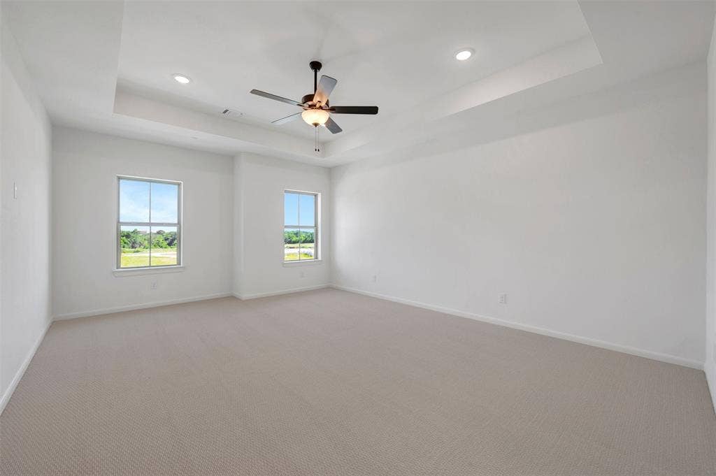 2860 Yampa Drive, McKinney, TX 75071 Spacious interior room featuring a tray ceiling with recessed lighting and a ceiling fan