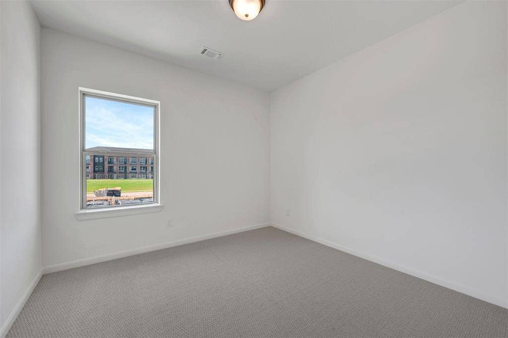2860 Yampa Drive, McKinney, TX 75071 Bright interior room with white walls and gray carpet