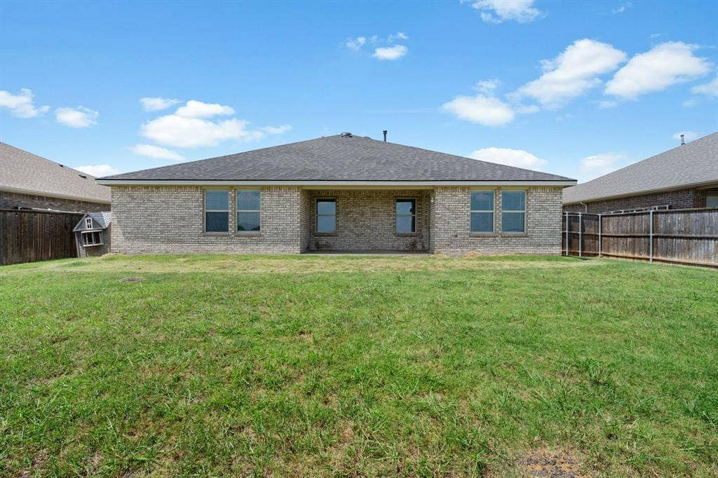 653 Bunker Hill Road, Fate, TX 75189 Expansive backyard featuring a manicured lawn, full brick exterior, and multiple windows