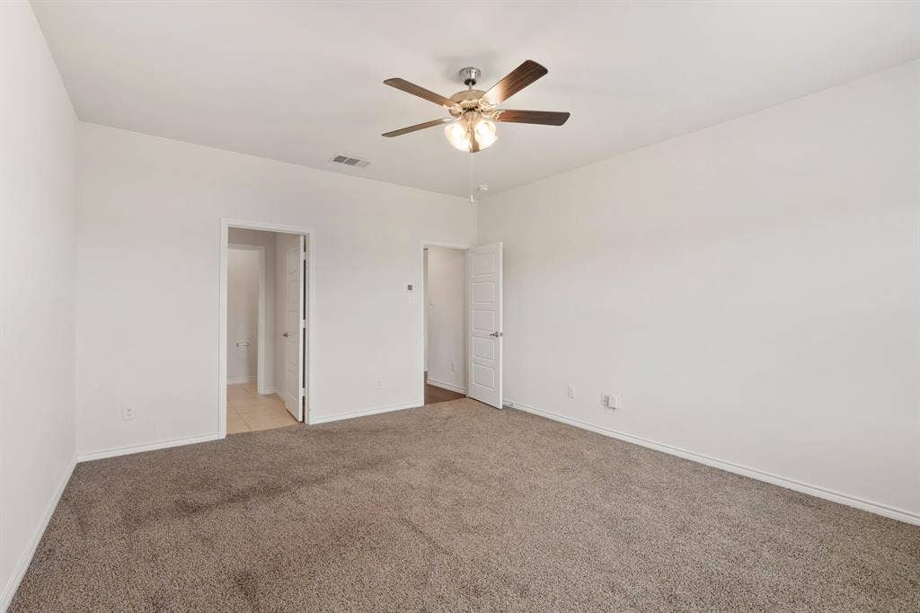653 Bunker Hill Road, Fate, TX 75189 Spacious room featuring neutral carpeting, light-colored walls, and a ceiling fan with integrated lighting