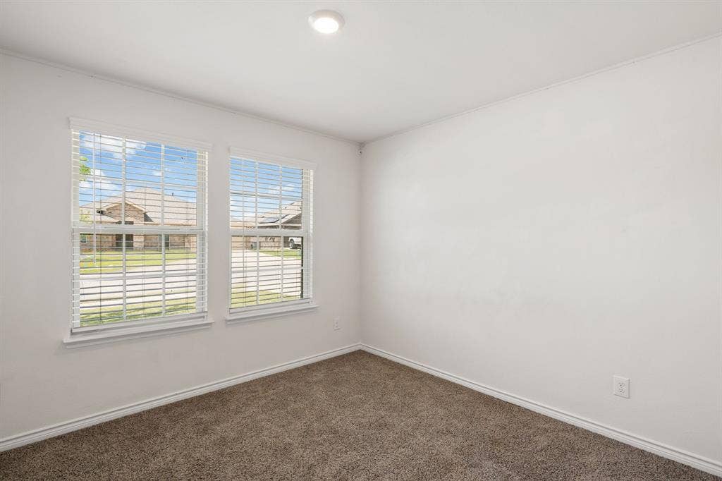 653 Bunker Hill Road, Fate, TX 75189 Carpeted room with two double-hung windows, white blinds, and white trim