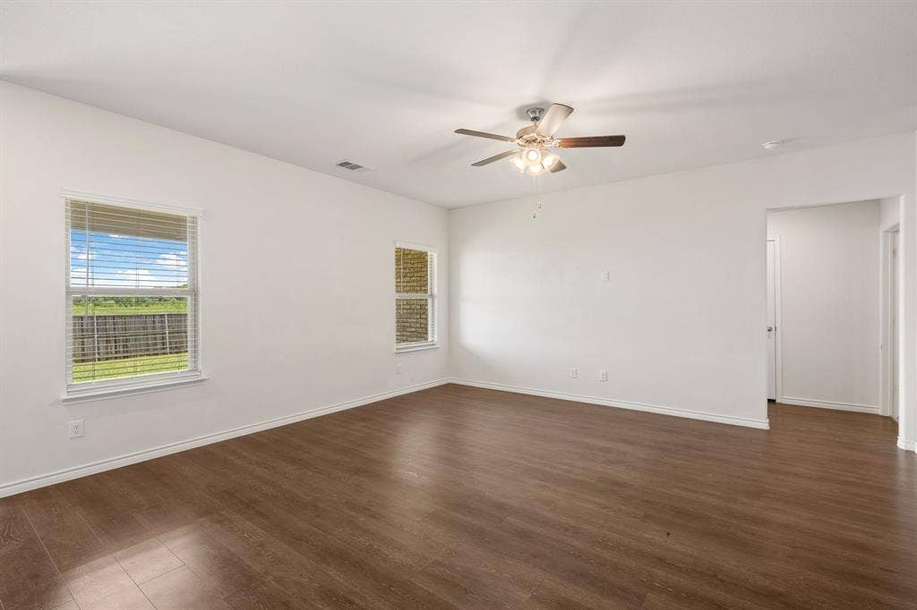 653 Bunker Hill Road, Fate, TX 75189 Spacious interior room featuring wood-finish flooring, white walls, and a ceiling fan with integrated lighting