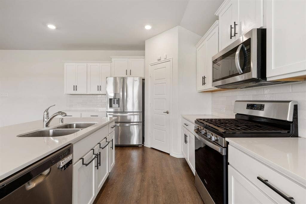 653 Bunker Hill Road, Fate, TX 75189 Contemporary kitchen featuring white cabinetry and stainless steel appliances