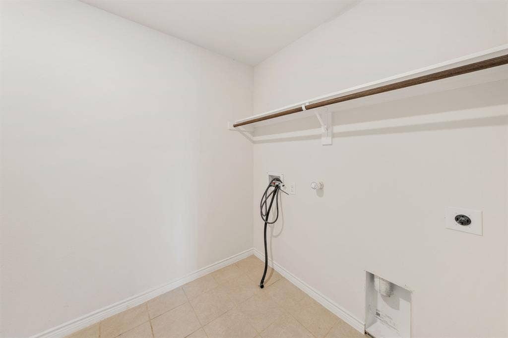 653 Bunker Hill Road, Fate, TX 75189 Laundry utility area featuring tiled flooring, a built-in shelf, and a clothing rod