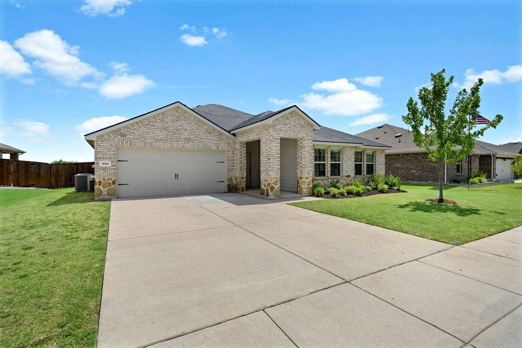 653 Bunker Hill Road, Fate, TX 75189 Single-story residence featuring a light brick facade with stone accents and BRAND NEW BLACK ROOF!