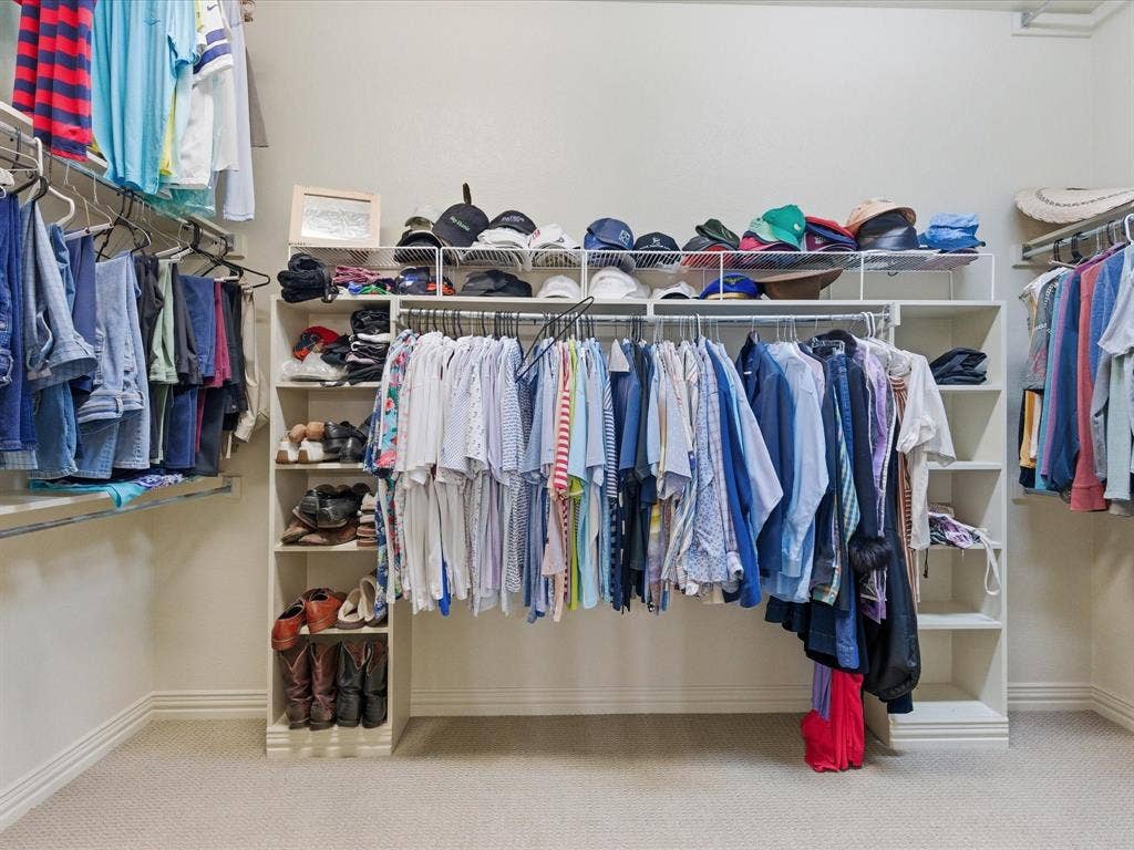 2115 N Hill Drive, Irving, TX 75038 Walk in closet with light colored carpet and plenty of hanging space and plenty of shelves.