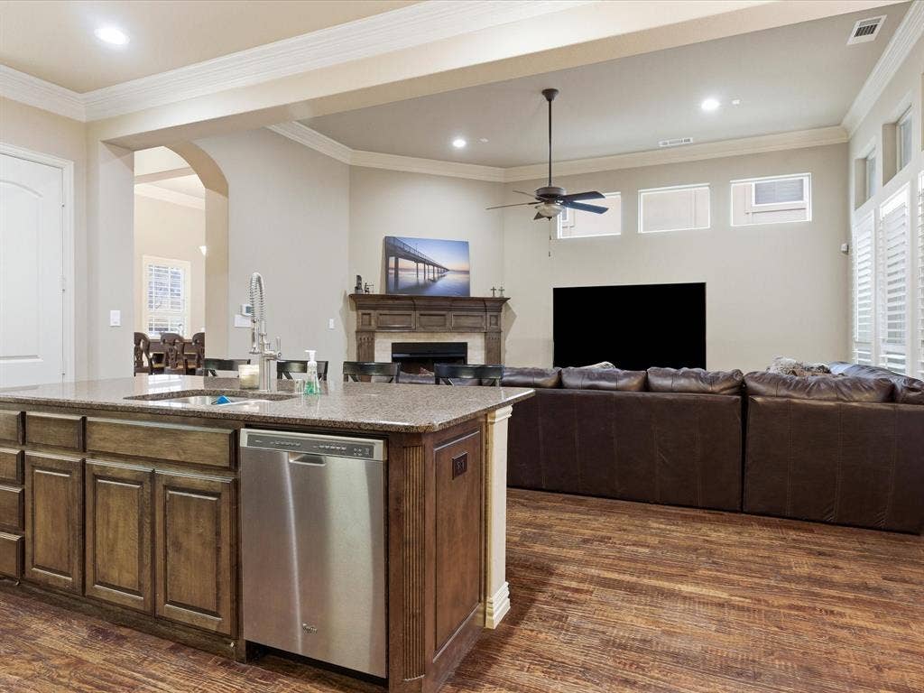 2115 N Hill Drive, Irving, TX 75038 Kitchen featuring open floor plan, dishwasher, a fireplace, granite counters, and a huge island with sink perfect for entering your friends and serving breakfast to the kids.