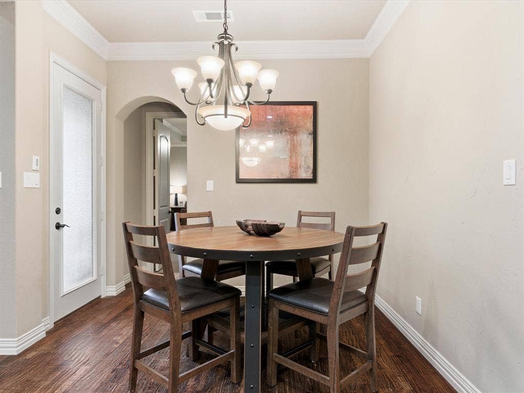 2115 N Hill Drive, Irving, TX 75038 Dining room with arched walkways, crown molding, hand scraped oak flooring, recess cans with led lighting and custom lighting fixture.