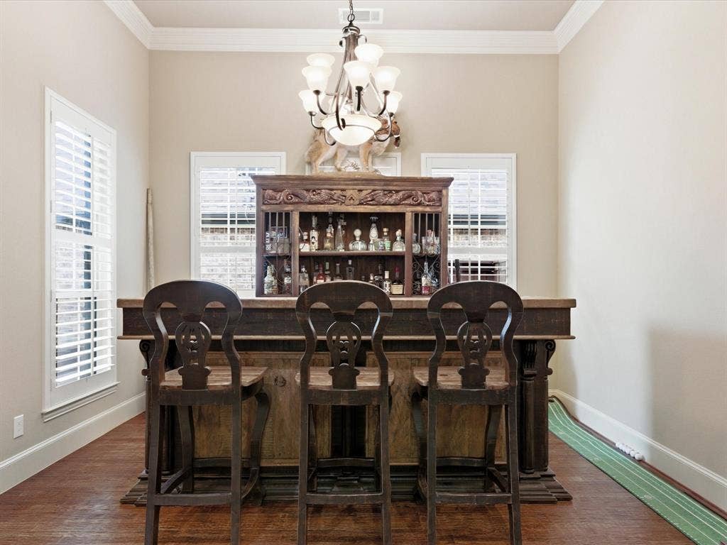 2115 N Hill Drive, Irving, TX 75038 Dining space featuring crown molding, custom lighting and dark wood finished floors. Custom wood plantation shutters.