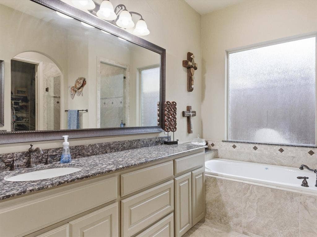 2115 N Hill Drive, Irving, TX 75038 Framed mirrors, granite tops with Kohler sinks and hand rubbed bronze plumbing fixtures. Decorative light fixture, jetted tub perfect for relaxing.