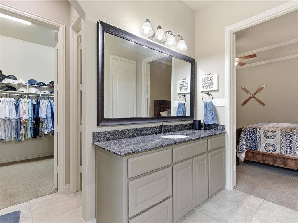 2115 N Hill Drive, Irving, TX 75038 Primary bathroom featuring 16 x16 tile floors, double vanities and a spacious walk in closet.