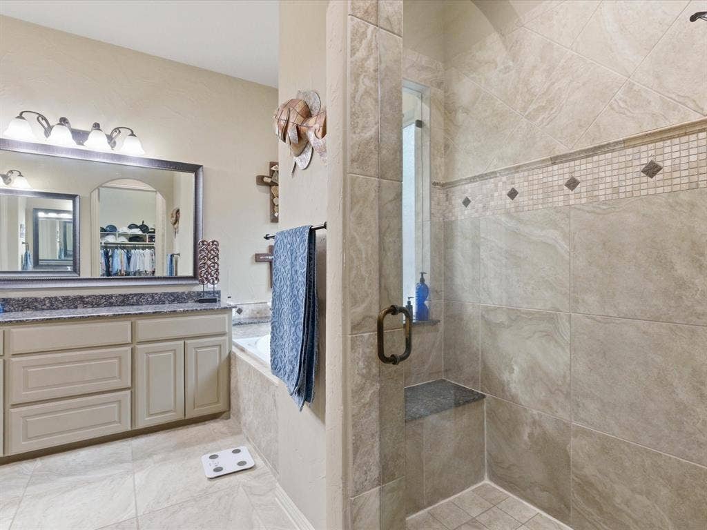 2115 N Hill Drive, Irving, TX 75038 Walk in shower with bench, larger 16x16 inch tile with nice decorative accents.