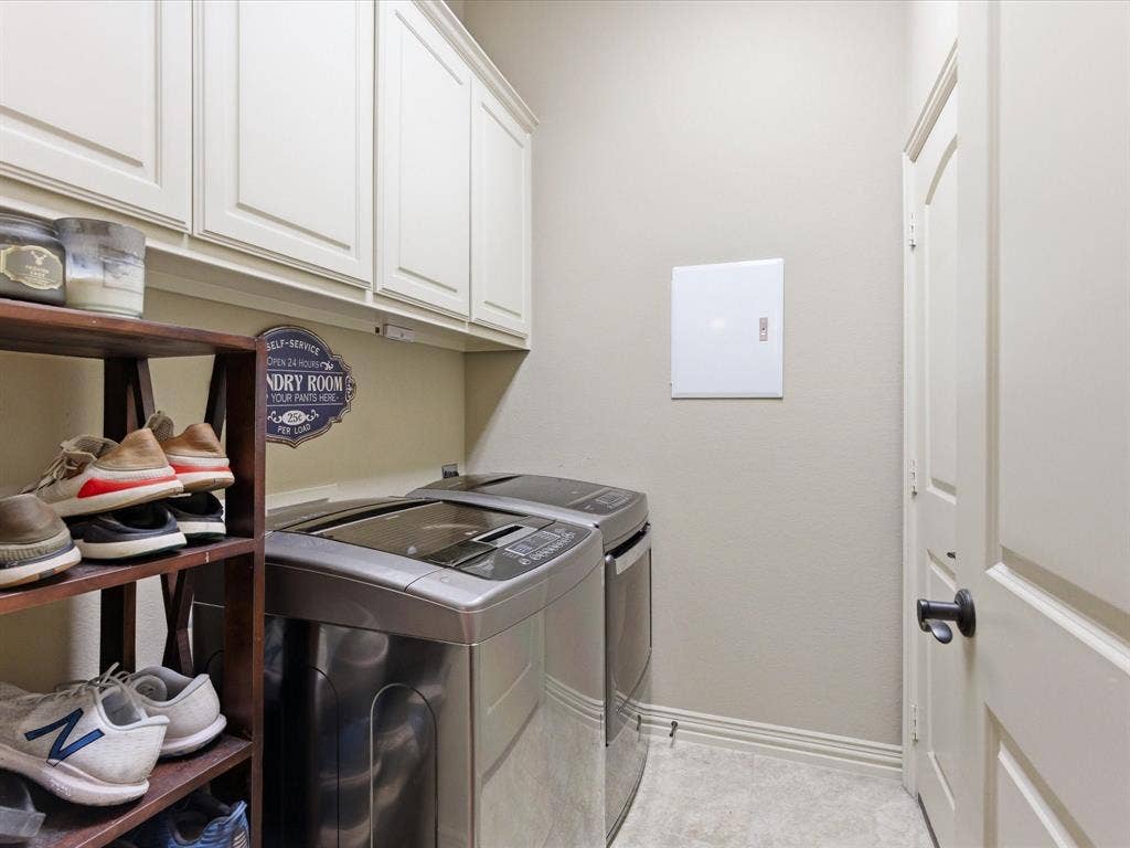 2115 N Hill Drive, Irving, TX 75038 Laundry room featuring cabinet space along with full sized washer and dryer with door to garage.