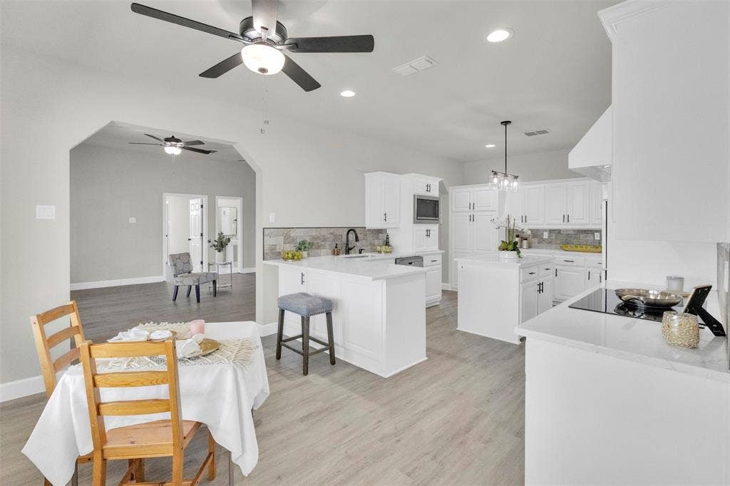 3415 Fm 3211, Caddo Mills, TX 75135 Dining room featuring ceiling fan, light wood-style flooring, arched walkways, and a chandelier