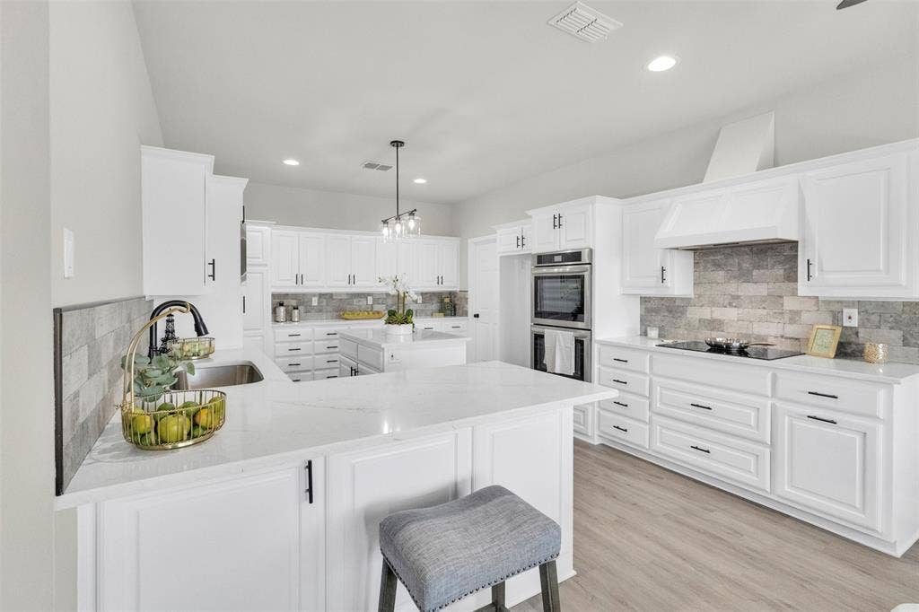 3415 Fm 3211, Caddo Mills, TX 75135 Kitchen with a peninsula, light stone counters, white cabinets, and decorative backsplash