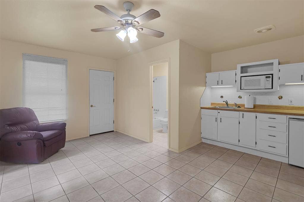 3415 Fm 3211, Caddo Mills, TX 75135 Kitchen featuring white cabinetry, white microwave, ceiling fan, dishwasher, and light tile patterned floors