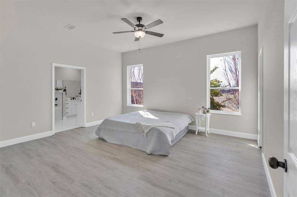 3415 Fm 3211, Caddo Mills, TX 75135 Bedroom featuring a ceiling fan, light wood finished floors, and ensuite bath