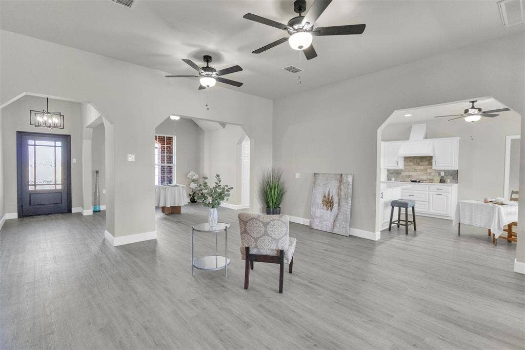 3415 Fm 3211, Caddo Mills, TX 75135 Living area with ceiling fan, arched walkways, light wood-type flooring, and hanging lights