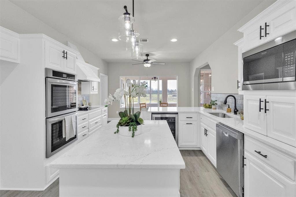 3415 Fm 3211, Caddo Mills, TX 75135 Kitchen with a peninsula, wine cooler, stainless steel appliances, white cabinetry, and a center island