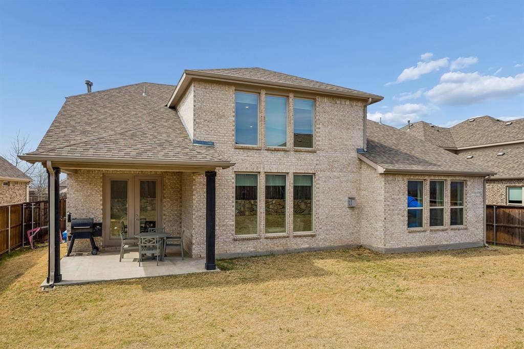 13674 Carmenita Drive, Frisco, TX 75035 Rear view of property featuring a fenced backyard, a patio area, roof with shingles, and brick siding