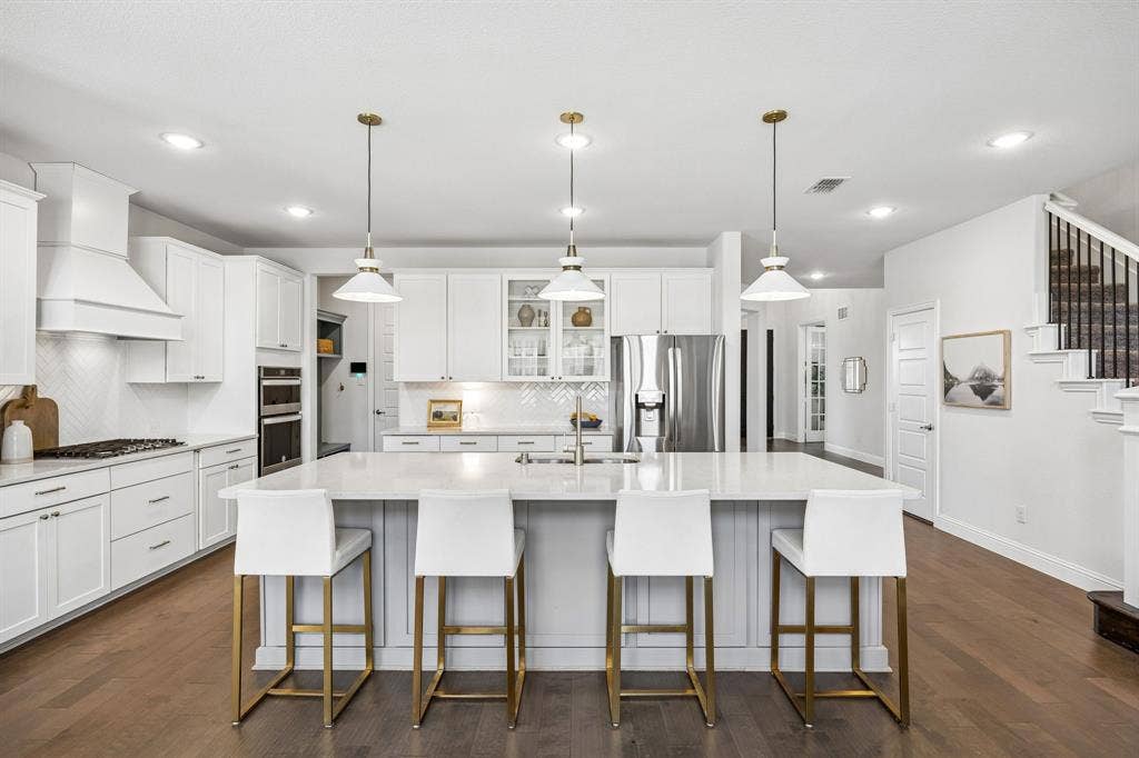 13674 Carmenita Drive, Frisco, TX 75035 Kitchen featuring glass fronted cabinets, a large island, stainless steel appliances, white cabinets, and dark wood finished floors