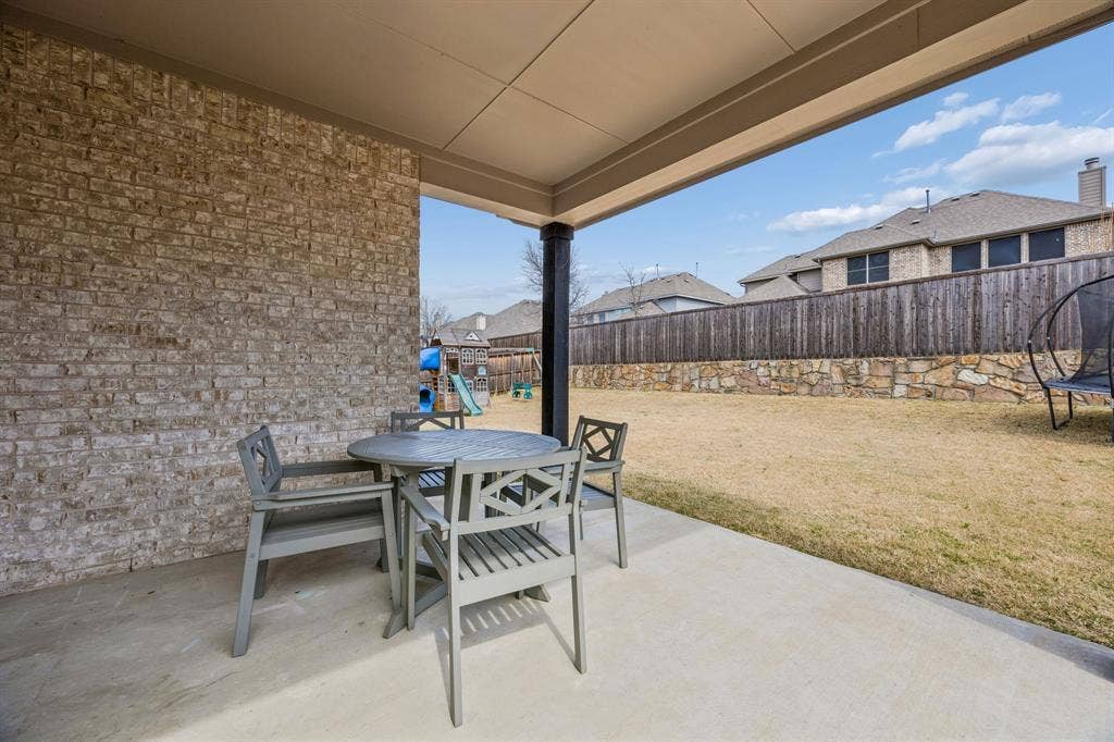 13674 Carmenita Drive, Frisco, TX 75035 Fenced backyard with a patio, a trampoline, and outdoor dining space