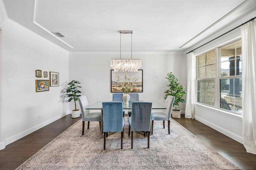 13674 Carmenita Drive, Frisco, TX 75035 Dining space featuring dark wood finished floors, a chandelier, and ornamental molding