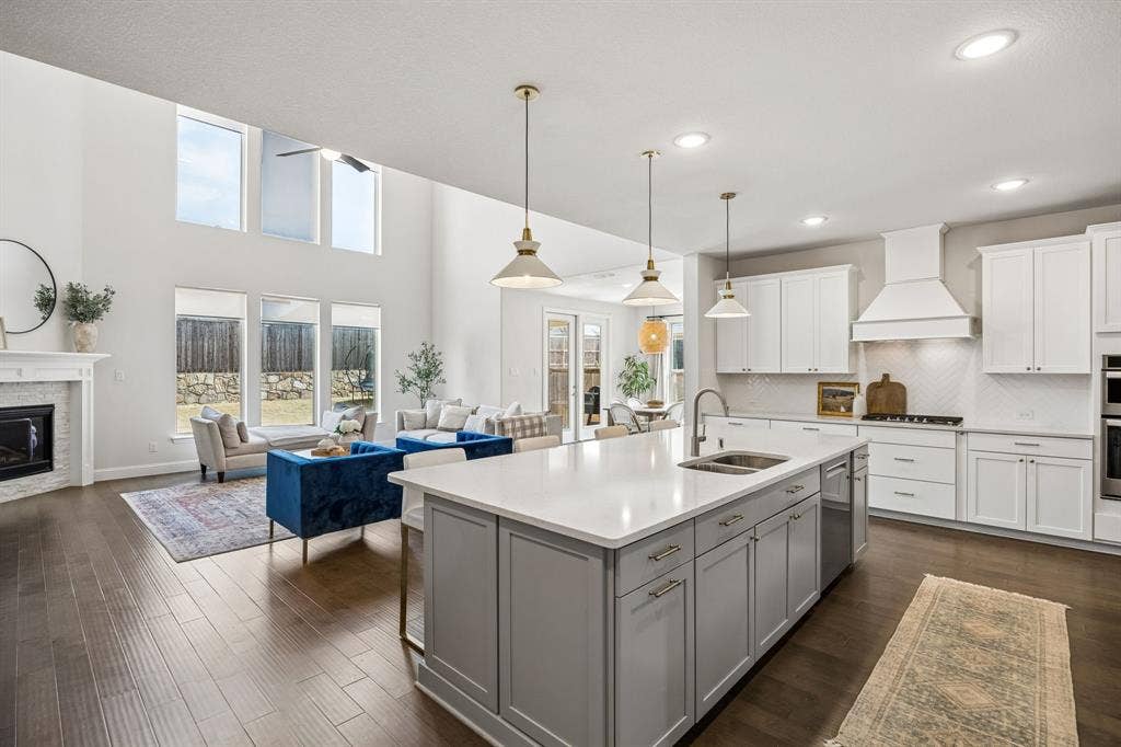 13674 Carmenita Drive, Frisco, TX 75035 Kitchen with open floor plan, pendant lighting, a kitchen island with sink, decorative backsplash, and two tone cabinetry