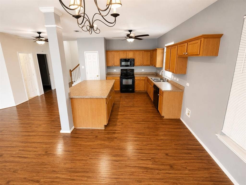 103 Denali Court, Terrell, TX 75160 Open-concept kitchen featuring wood-finish flooring, a central island with countertop, natural wood cabinetry, and black appliances